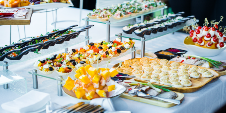 Bufê com seleção variada de aperitivos gourmet em evento, simbolizando a dúvida entre "buffet” e “biffet.