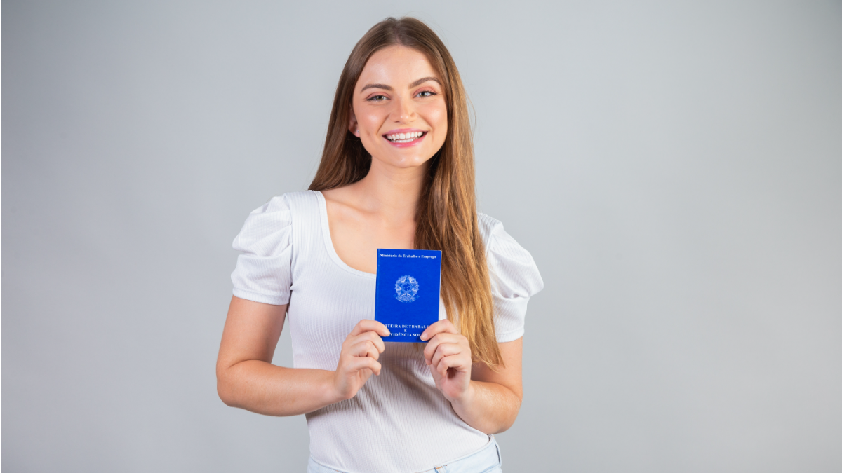 Jovem segurando carteira de trabalho.