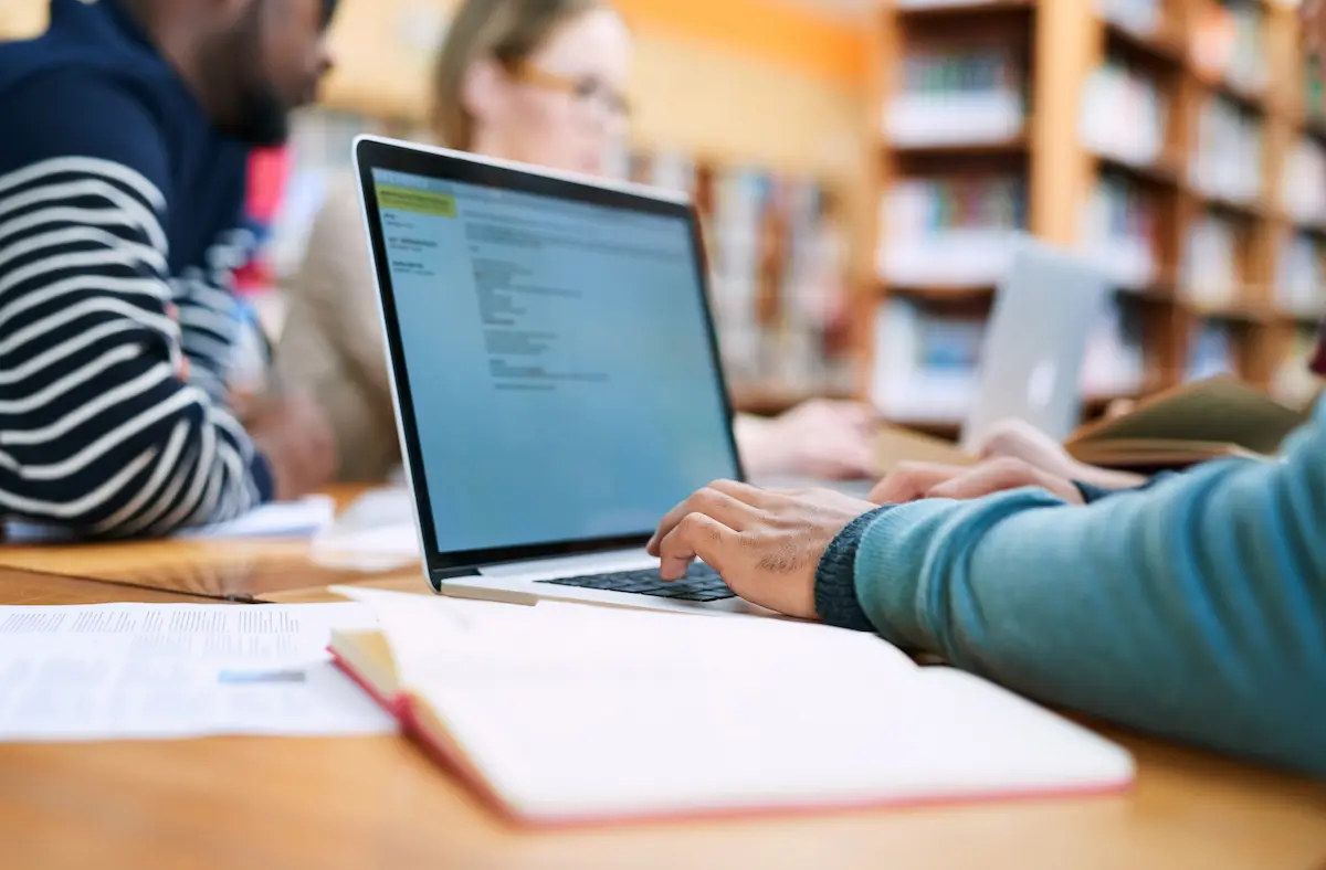 Estudante utilizando notebook em ambiente de estudos para inscrição em estágio do INSS.