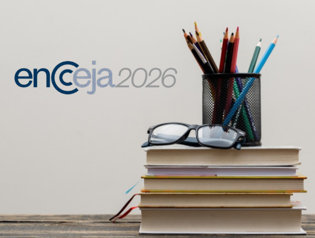 Livros empilhados, óculos e porta-lápis com logo do Encceja 2026 ao fundo.