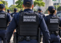 Grupo de guardas municipais uniformizados patrulha rua arborizada com viatura à direita, simbolizando a escolha da banca do concurso Guarda de Recife