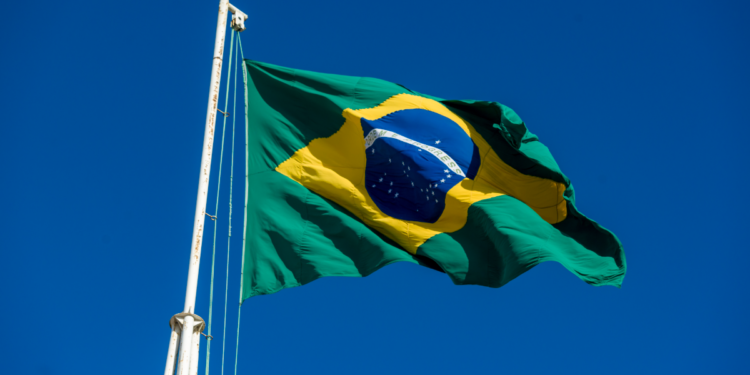 Bandeira do Brasil voando em céu azul claro.