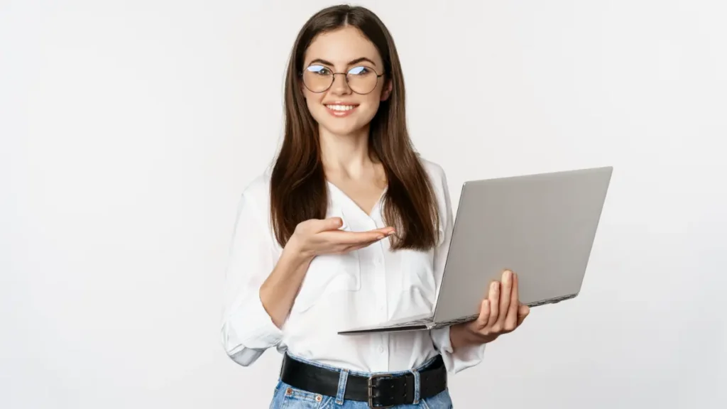 Jovem sorridente segurando notebook.