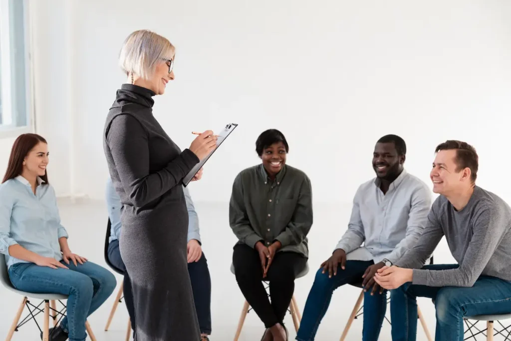 Profissional conduzindo dinâmica em grupo com pessoas de diferentes perfis.