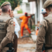 Grupo de pessoas e dois policiais militares de costas.