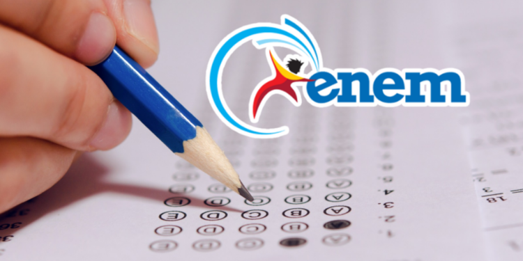 Mão preenchendo gabarito de prova e logo do Enem ao lado.