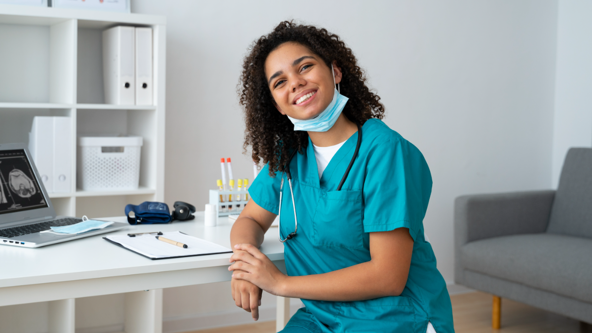 Técnica de enfermagem sorridente em consultório moderno.