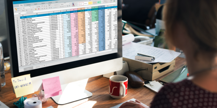 Mulher analisando planilha no Excel em ambiente de escritório.
