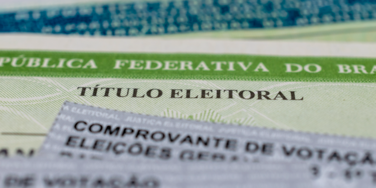 Título de eleitor brasileiro e comprovante de votação em destaque.