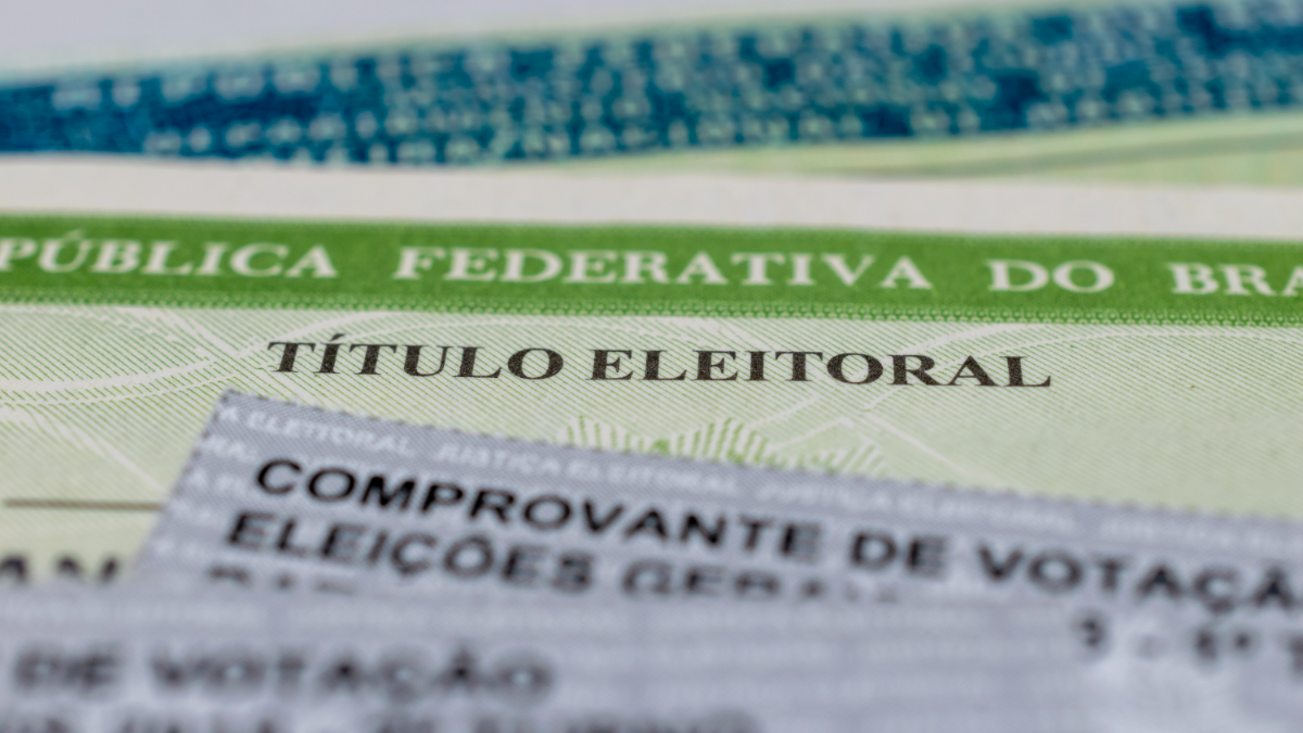 Título de eleitor brasileiro e comprovante de votação em destaque.