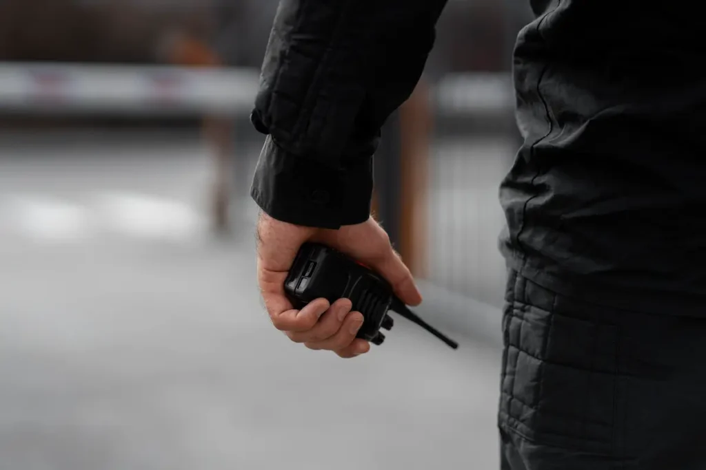 Vigilante com rádio comunicador durante atividade de segurança.