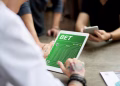 Imagem ilustrativa de pessoa segurando tablet com tela de site de apostas esportivas, ao lado de outras pessoas com celular, em referência ao aviso do governo sobre as bets