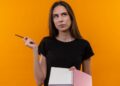 Imagem ilustrativa: jovem com caderno e lápis olha para o lado pensativa, sobre a dúvida entre blecaute ou blackout