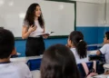 Estudante de licenciatura realiza atividade de formação docente em sala de aula de escola pública.