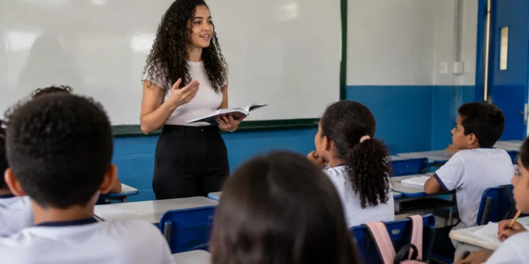 Estudante de licenciatura realiza atividade de formação docente em sala de aula de escola pública.