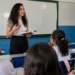Estudante de licenciatura realiza atividade de formação docente em sala de aula de escola pública.