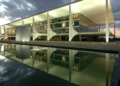 Fachada iluminada do Palácio do Planalto refletida no espelho d'água ao entardecer, sede do governo brasileiro em Brasília.