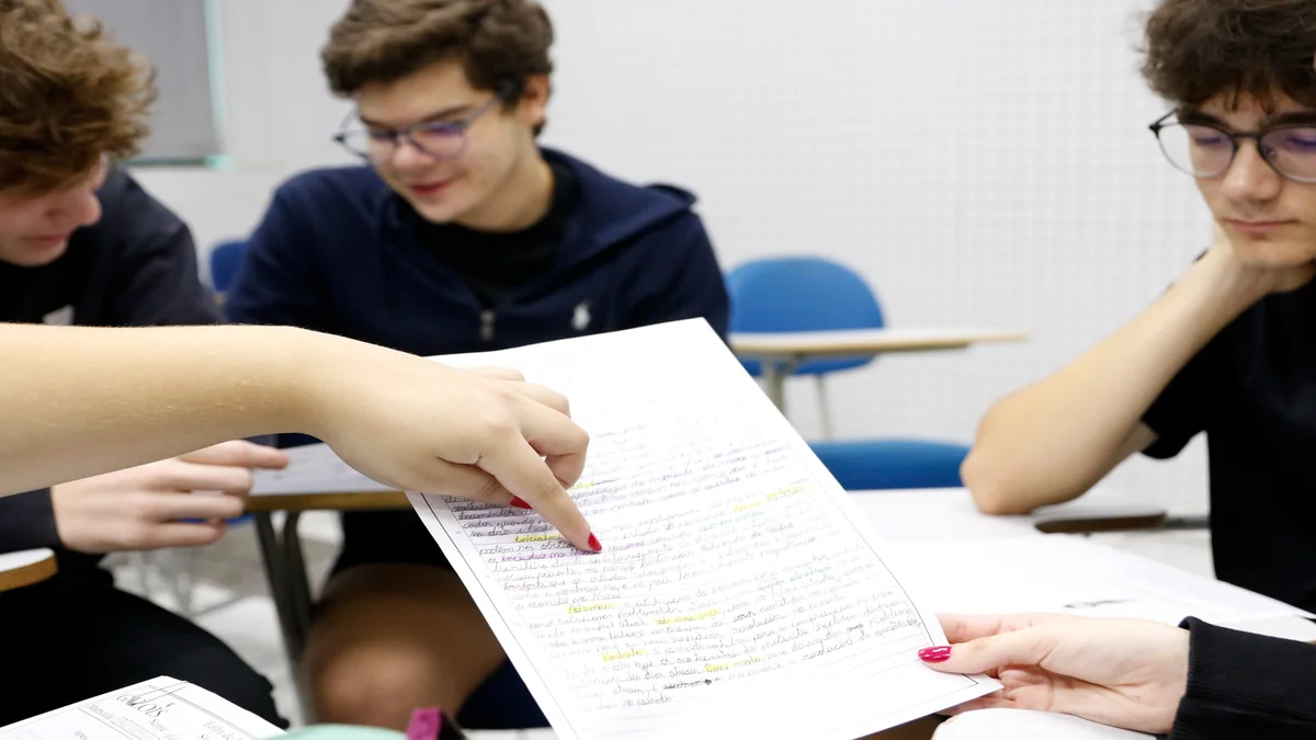 Estudantes analisam redação escrita à mão durante atividade de preparação para o Enem.