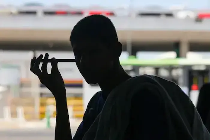 Estudante usando celular representa restrições ao uso de dispositivos nas escolas avaliadas pelo Pisa 2025.
