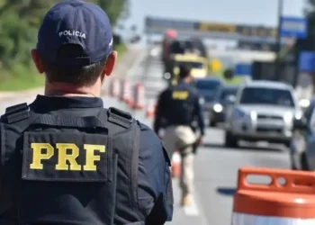 Policial rodoviário federal durante fiscalização em rodovia federal.