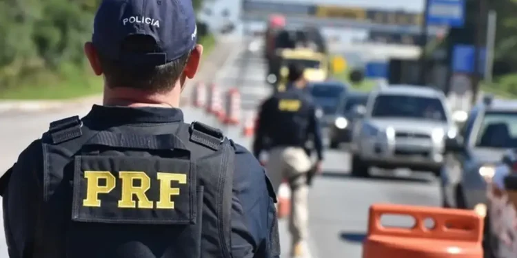 Policial rodoviário federal durante fiscalização em rodovia federal.