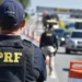 Policial rodoviário federal durante fiscalização em rodovia federal.