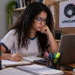 Jovem estudando em ambiente de preparação acadêmica, com livros e notebook, representando a rotina de estudos para o vestibular da Unicamp 2027.
