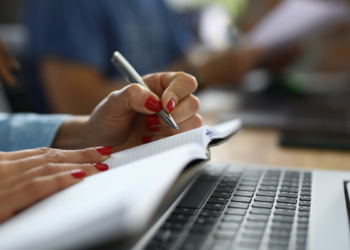 Pessoa realizando anotações durante um curso livre com material de estudo e computador, representando a qualificação profissional e a diferença entre certificado e diploma.