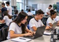 Estudantes participam de aula prática em curso técnico com uso de computadores e equipamentos profissionais.