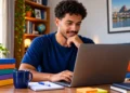 Jovem brasileiro estudando pelo notebook com materiais de apoio, representando cursos de qualificação profissional.