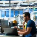 Pessoa trabalhando em ambiente industrial com computador, representando cursos técnicos e qualificação profissional em 2026.