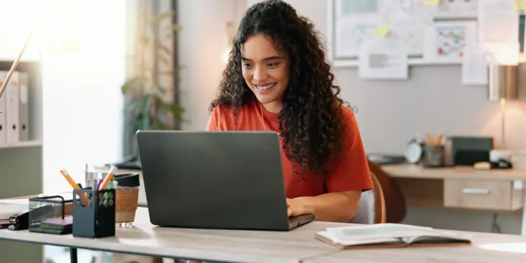 Mulher estudando curso técnico profissionalizante com notebook em ambiente de estudos.
