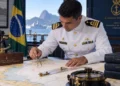 Hidrógrafo da Marinha do Brasil analisando carta náutica com instrumentos de navegação