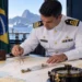 Hidrógrafo da Marinha do Brasil analisando carta náutica com instrumentos de navegação