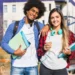 Dois estudantes com livros em frente a uma universidade representam graduações apontadas como algumas das mais valiosas do mercado.