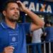 Trabalhador com carteira de trabalho em frente a uma agência da Caixa, representando a dúvida sobre o depósito do Abono Salarial PIS/Pasep em setembro.