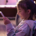 Criança utilizando celular em ambiente doméstico representando o uso da internet por menores de idade.
