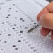 Participante preenchendo cartão de respostas do Encceja 2026 durante prova objetiva do exame.