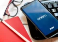 Celular com aplicativo do Enem ao lado de materiais de estudo representa a preparação para a prova de 2026.