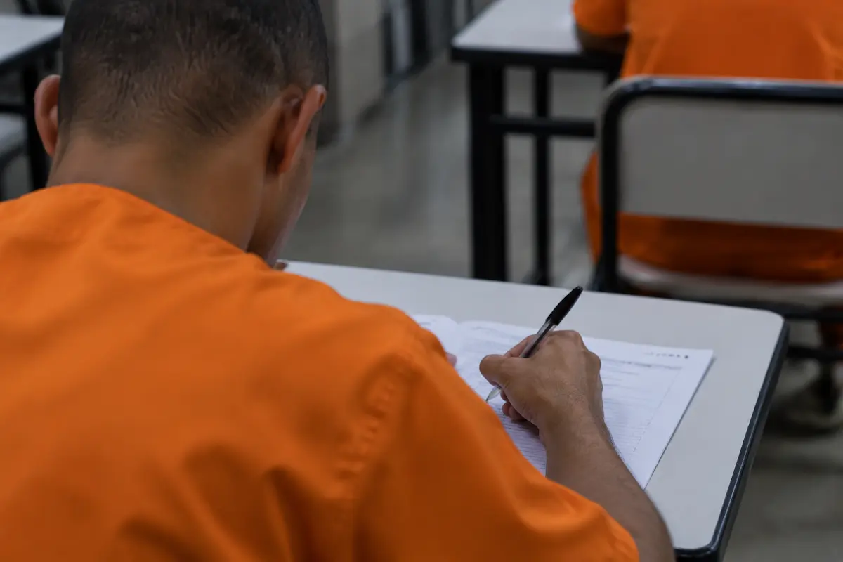 Pessoa privada de liberdade realiza prova escrita do Enem PPL em sala de aplicação do exame.