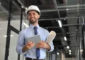 Engenheiro civil analisa projeto técnico em ambiente profissional representando cálculo do piso salarial conforme horas trabalhadas.