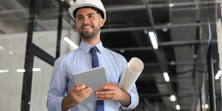 Engenheiro civil analisa projeto técnico em ambiente profissional representando cálculo do piso salarial conforme horas trabalhadas.
