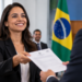 Servidora pública recebe documento de nomeação durante cerimônia de ingresso no serviço público.