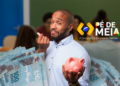 Homem jovem segurando cofrinho rosa e notas de 100 reais com logo Pé-de-Meia ao fundo, simbolizando a regras para exclusão do programa em 2027.