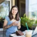 Mulher com celular ao lado de notebook representa acesso ao Fies Empreendedor para contratação de crédito.