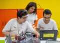 Imagem ilustrativa: estudantes com camisetas da Firjan Senai usam notebook em sala de aula, sobre cursos técnicos gratuitos