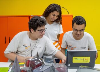 Imagem ilustrativa: estudantes com camisetas da Firjan Senai usam notebook em sala de aula, sobre cursos técnicos gratuitos