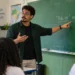 Professor explicando no quadro qual é a forma correta: “pode vir” ou “pode vim”, durante uma aula de português.