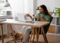 Profissional trabalha em home office com notebook e headset enquanto participa de atendimento online.