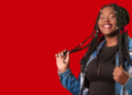 Jovem sorridente de jaqueta jeans posando sobre fundo vermelho, na identidade visual usada na divulgação do programa jovem aprendiz do iFood.